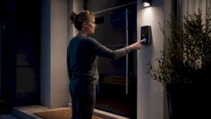 Woman using home intercom at front door