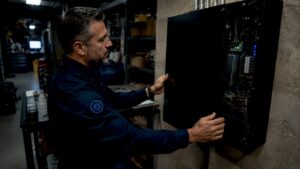Technician inspecting access control panel in server room